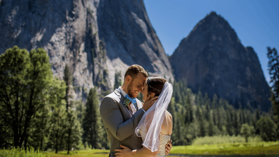 A couple posing for a photoshoot with the Yosemite in the backdrop - Narrow Gauge Inn - A Serenite Hotel Near Fish Camp.