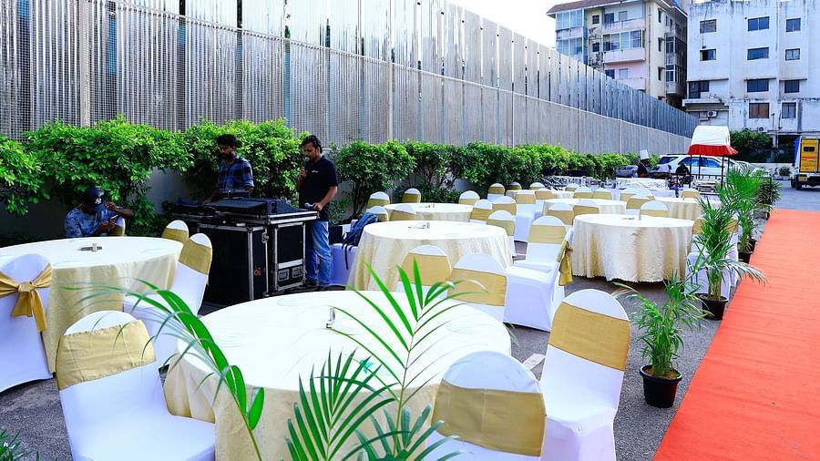 A well-organised outdoor event setup with round tables, chairs, and a red carpet path - Grand Continent, Brookefield