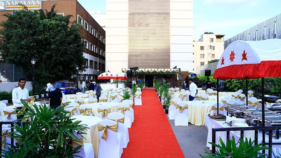 A spacious outdoor dining setup with white and gold chairs and a red carpet leading to the main venue - Grand Continent, Brookefield