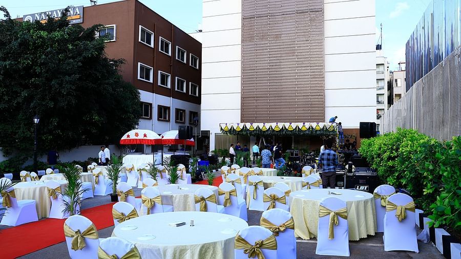 A stylish outdoor event setup with white and gold chairs and a red carpet path leading through the venue - Grand Continent, Brookefield
