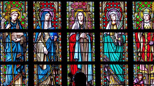 stained glass art of Lady Mary in different poses inside a church 