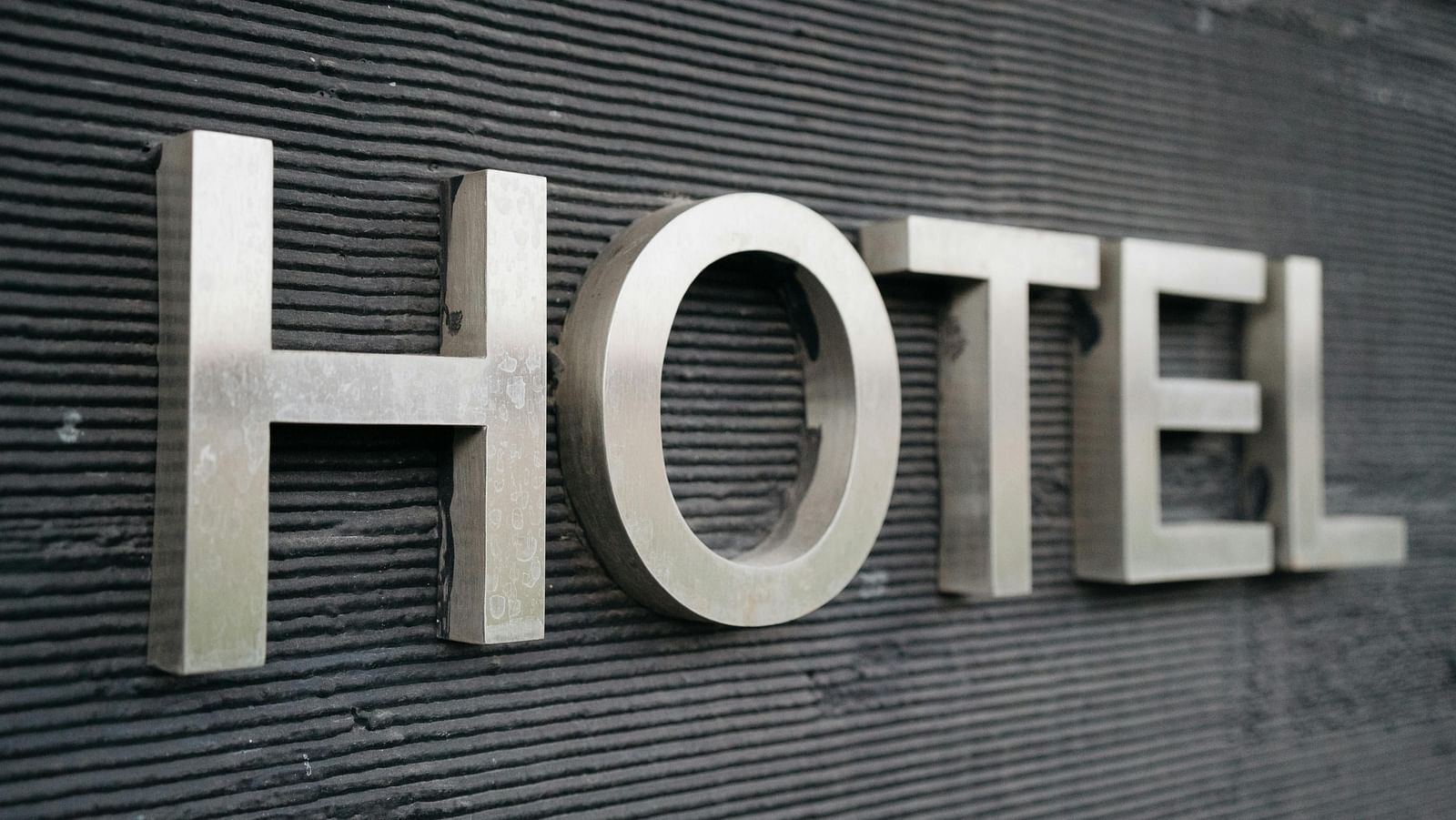 A signboard of a Hotel sign on a wall.