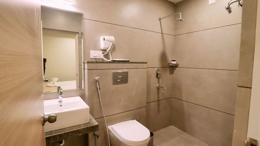 Image of the washroom of Super Deluxe Room with a sink and a toilet at Clarks Inn Express, Udaipur.