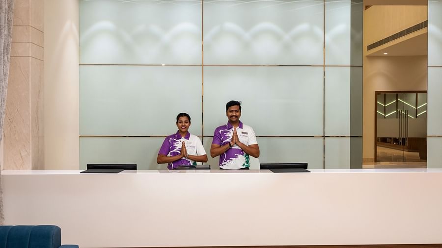 two staff members behind the reception desk - The Orchid Hotel, Jamnagar
