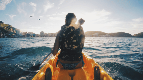 A backview of a person boating during the day
