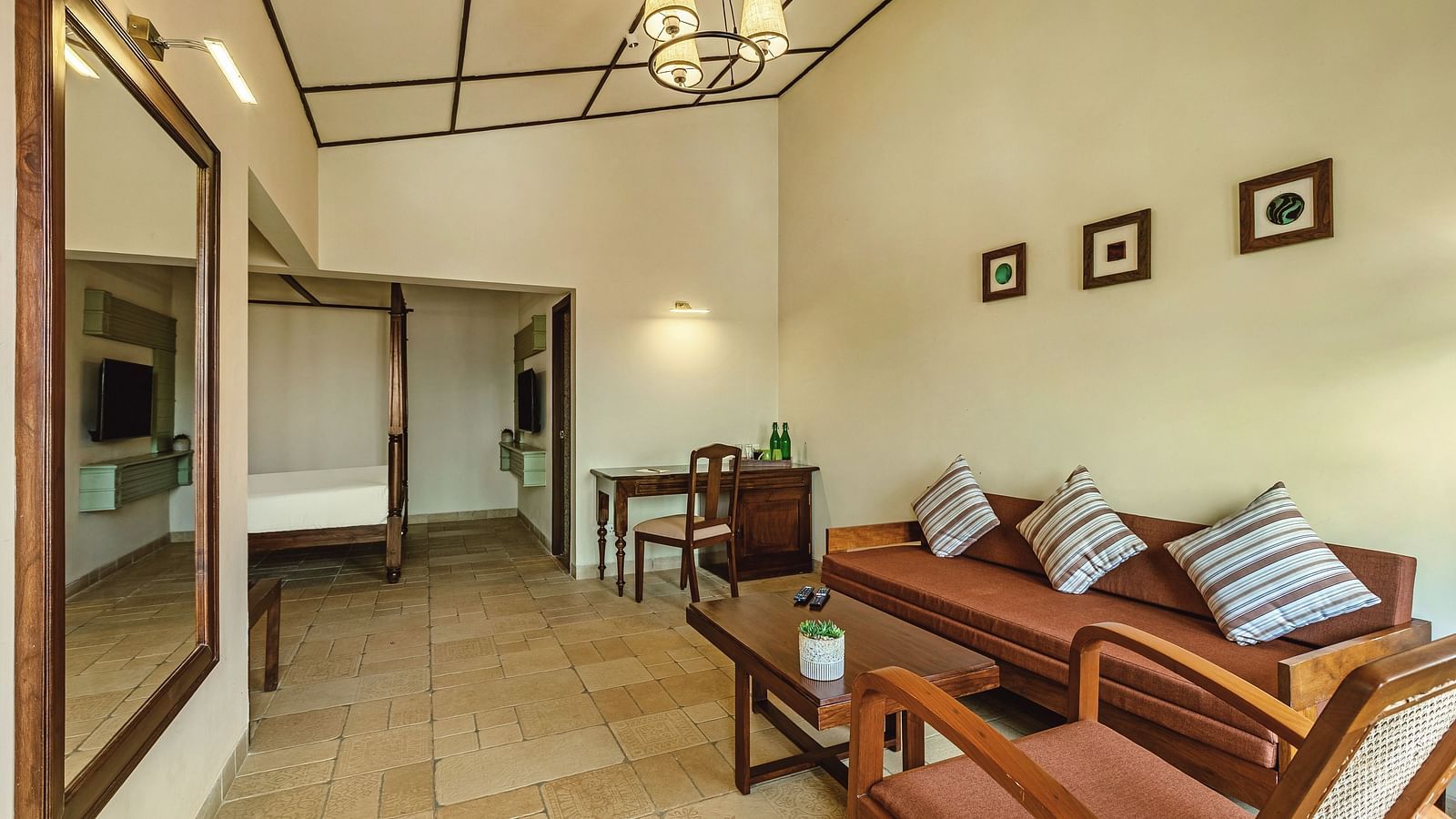 Spacious living area at Mango Hill Shola, Ooty featuring a stylish couch with patterned cushions, wall art, and soft ambient lighting.