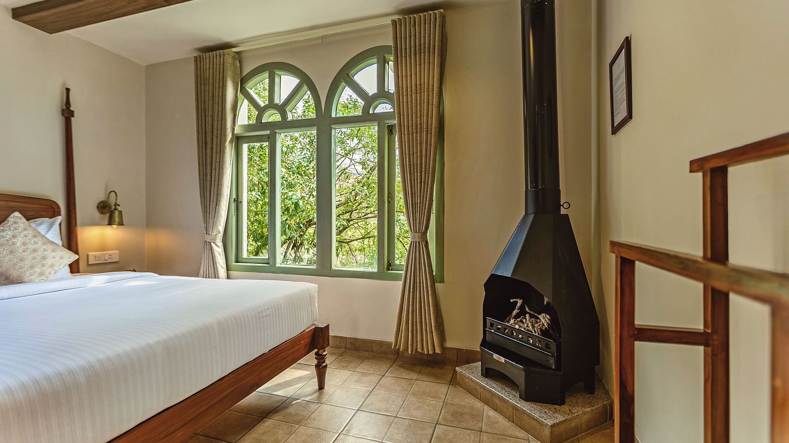 Junior Suite with Bathtub featuring a fireplace and serene views through tall windows at Mango Hill Shola, Ooty.