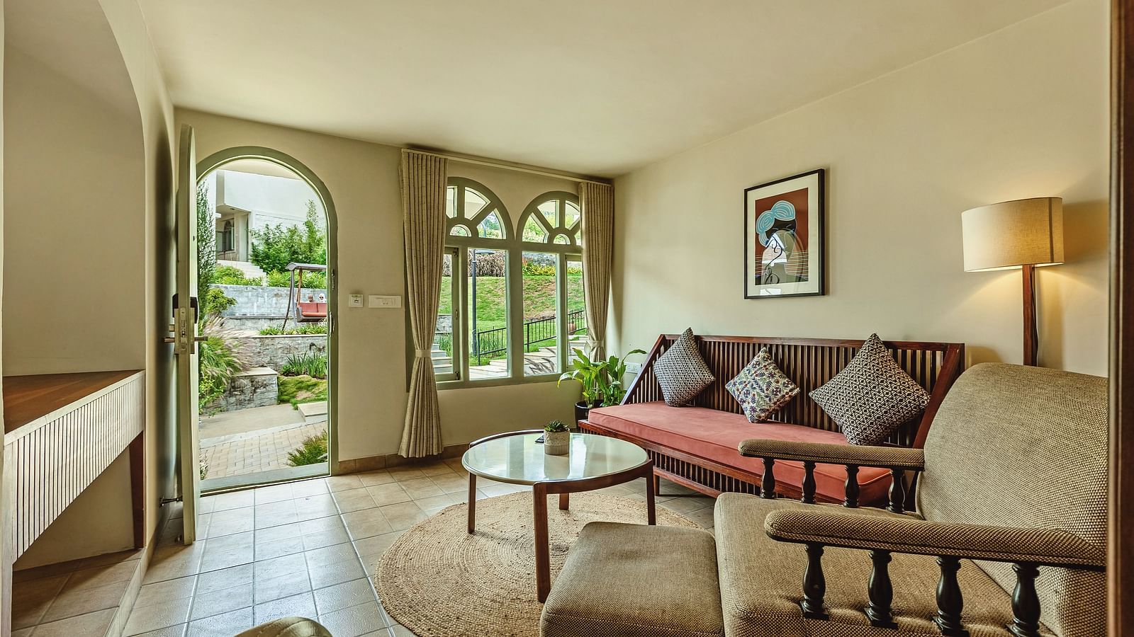 Inviting lounge space at Mango Hill Shola, Ooty with cushioned wooden seating and wide windows letting in natural light.