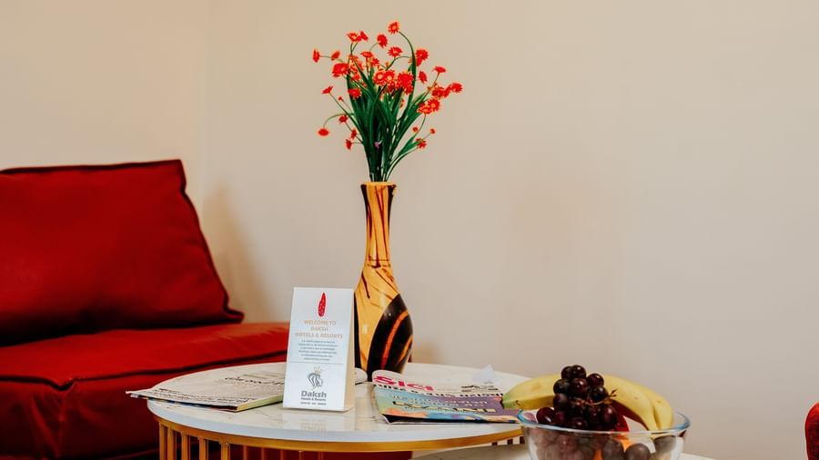 A close-up shot of the coffe table in the Bliss Room at Daksh The Grand Goverdhan, Dwarka, featuring a golden flower vase kept on it.