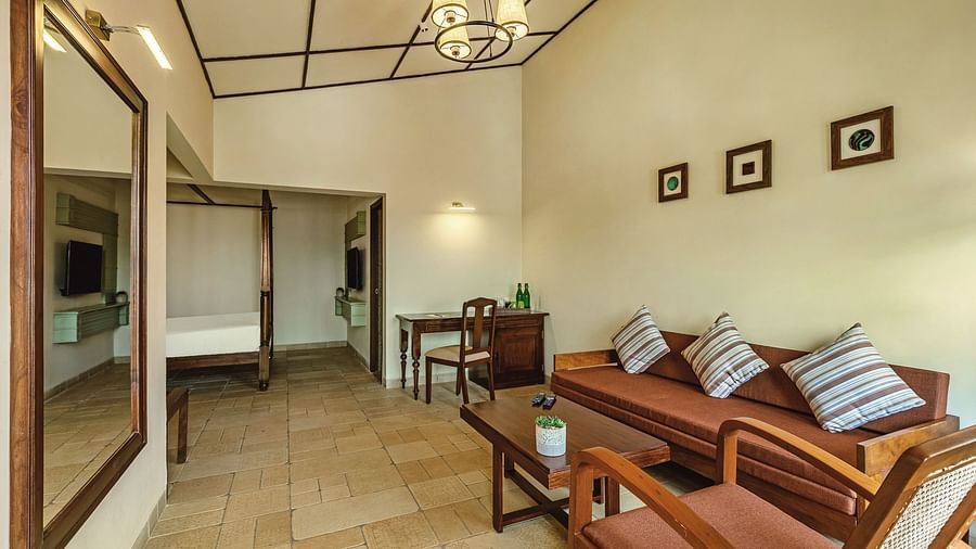 Spacious living area at Mango Hill Shola, Ooty featuring a stylish couch with patterned cushions, wall art, and soft ambient lighting.
