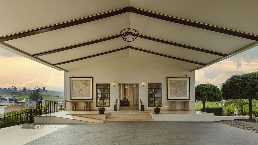 Covered outdoor veranda at Mango Hill Shola, Ooty, with tall pillars, arched doorways, and views of the natural landscape beyond.