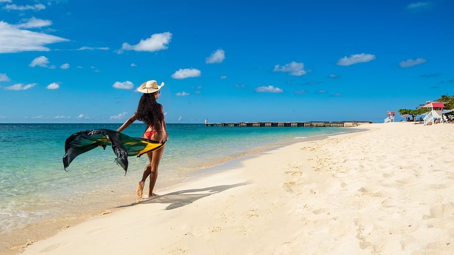 An image of a woman waling on a beach in her beach dress - S Hotel Montego Bay, Jamaica