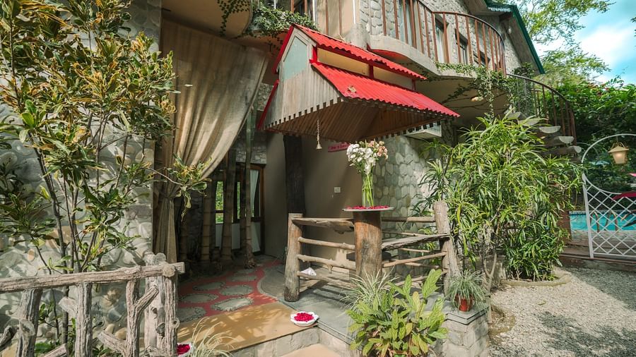 A multi-level structure built into trees, with a red fabric element visible, daytime setting.