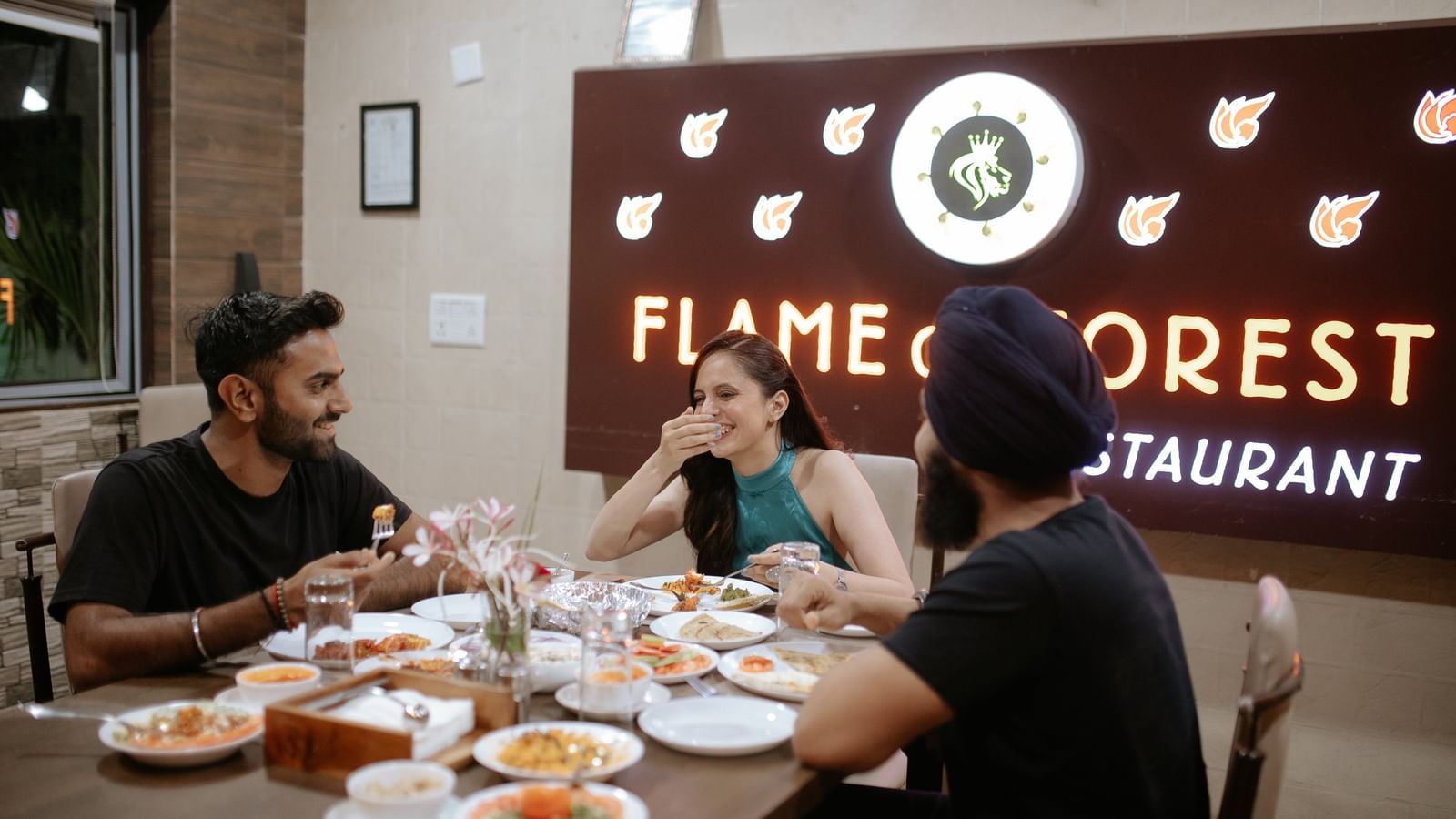 Guests enjoying a meal together at the Flame of Forest restaurant at Daksh Resort and Amusement Park.