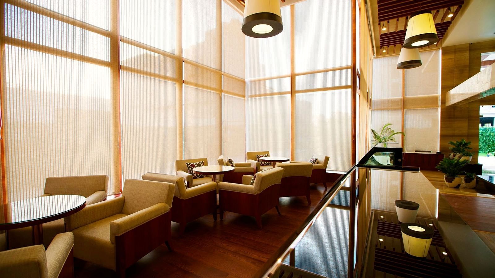 The cafe at the Ramada by Wyndham, Ghaziabad, Vasundhara with tall glass windows covered with a thin cloth curtain blocking the sunlight from outside.