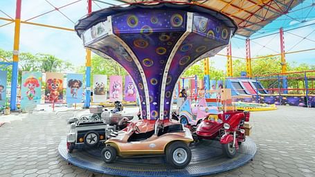 A colourful amusement ride at MGM Dizzee World featuring mini cars circling under a bright canopy, designed for kids and families.