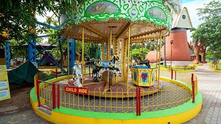 A classic carousel ride at MGM Dizzee World with vibrantly painted horses and a shaded structure, inviting young guests to enjoy the spin.