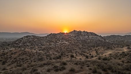 Image of sunrise taken from a far in a desert area