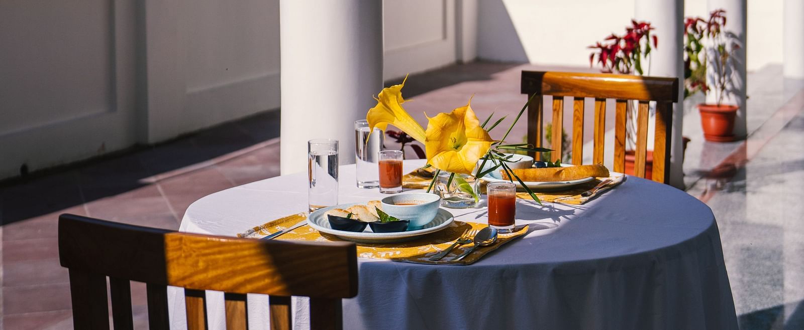A table for two, neatly set for dining on the balcony at BluSalzz Villas - The Green Roof, Bhimtal.