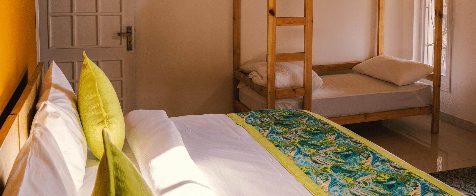 A side view of a neatly made bed with bunk beds to the side at BluSalzz Villas - The Green Roof, Bhimtal.