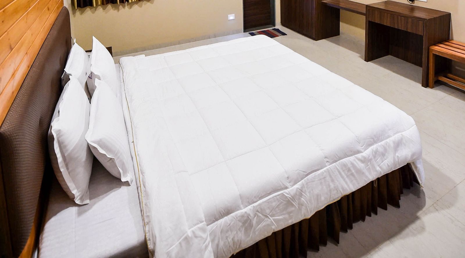 Interior of Deluxe Cottage at the Kanila Resort with a bed, bedside tables, and a ceiling fan.