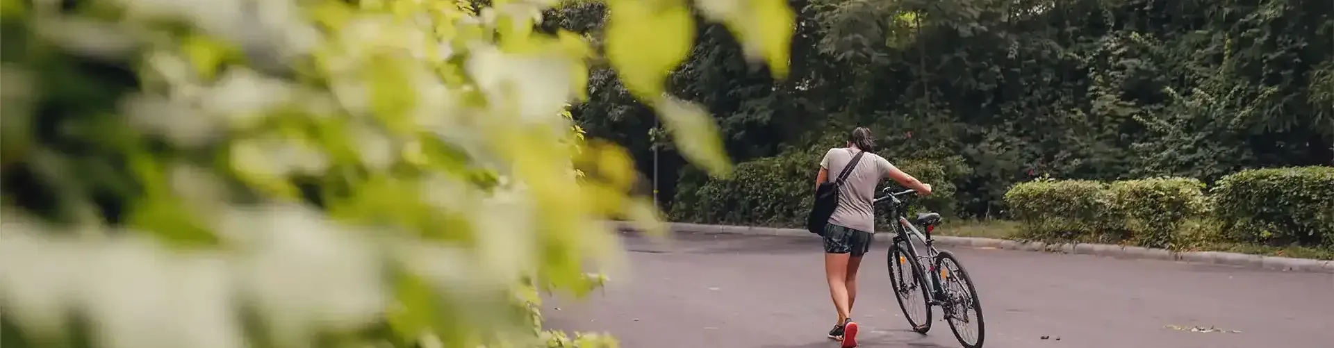a man with a bicycle with greenery st Karma Chalets.