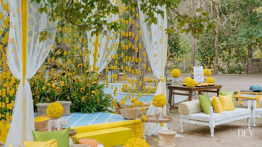 An outdoor space with decorated seating and fabric hangings, possibly for an event or celebration.