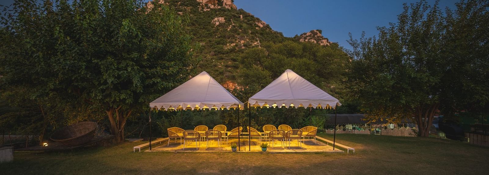Night view of an open dining space adorned with sheer curtains and glowing lights at Valley by Grassfield.