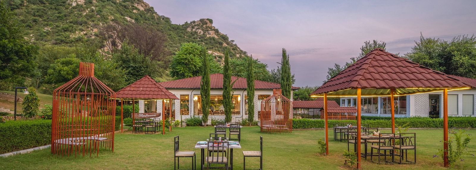 An open space at Valley by Grassfield, featuring tables and chairs, with mountains providing a stunning backdrop.