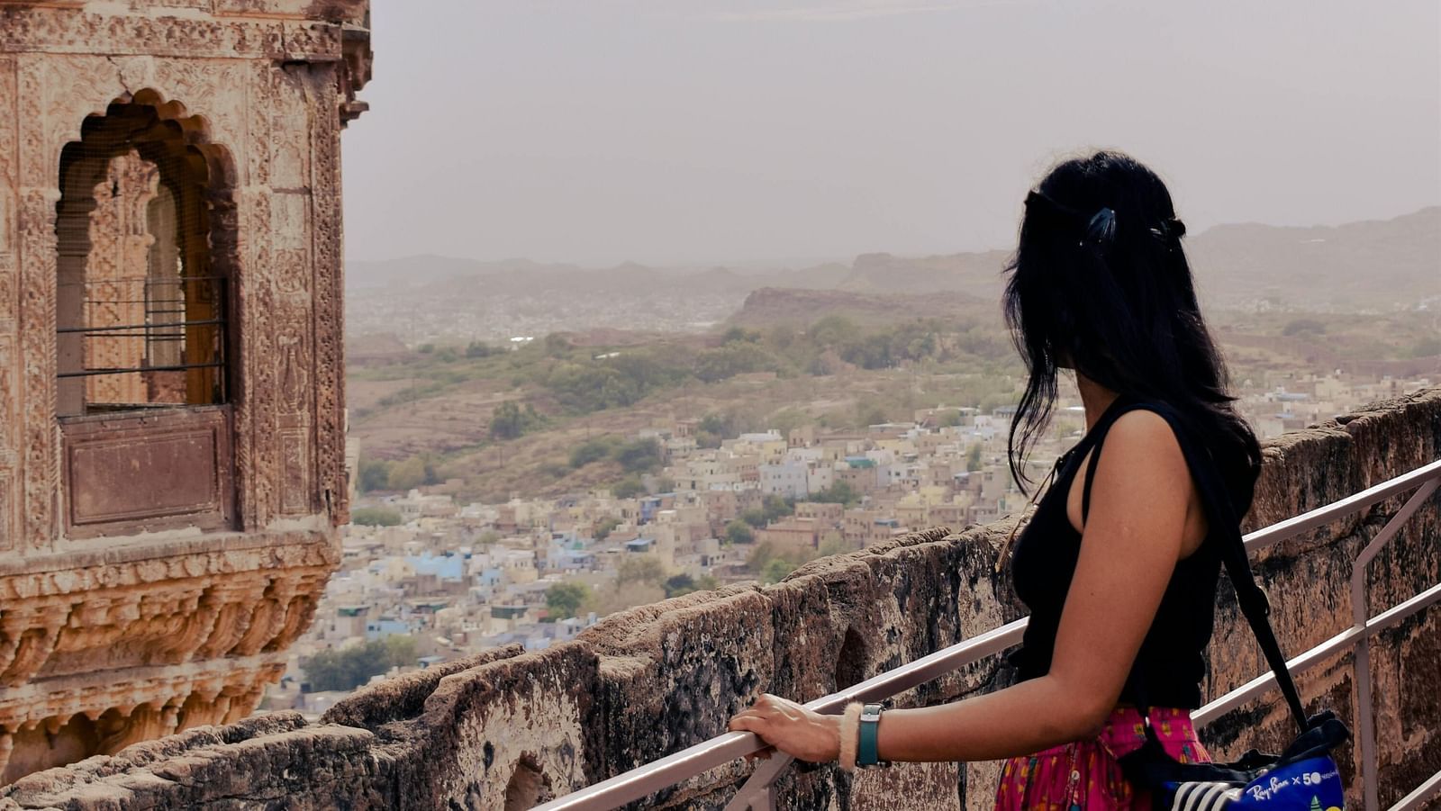 A woman looking out over the city of Jaisalmer from a balcony of Jaisalmer Fort in rajasthan
