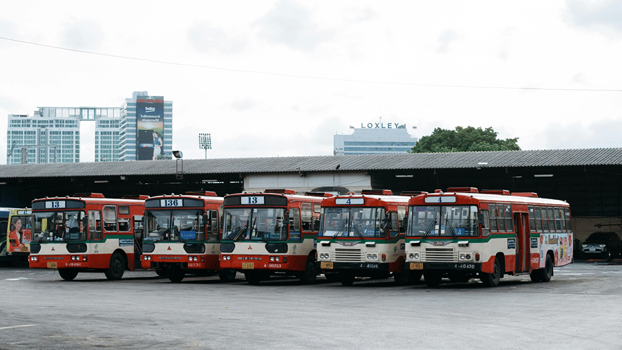 Five buses parked close together at a bus depot