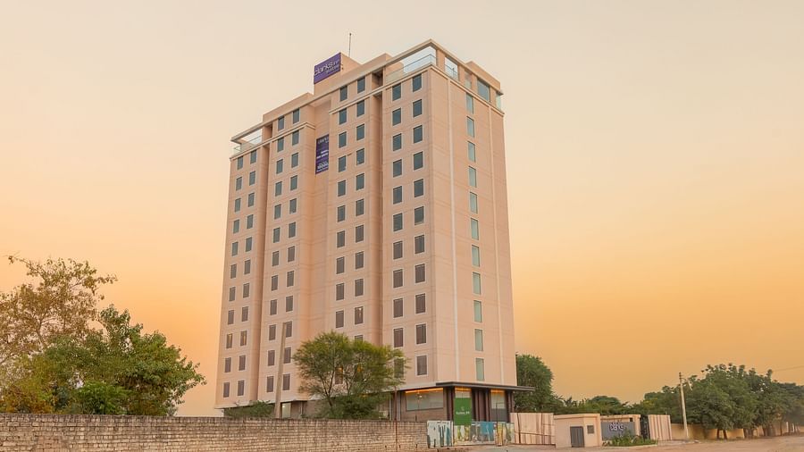 Facade of Clarks Inn Suites Jaipur, Ajmer Road in the late afternoon under a peach-orange sky