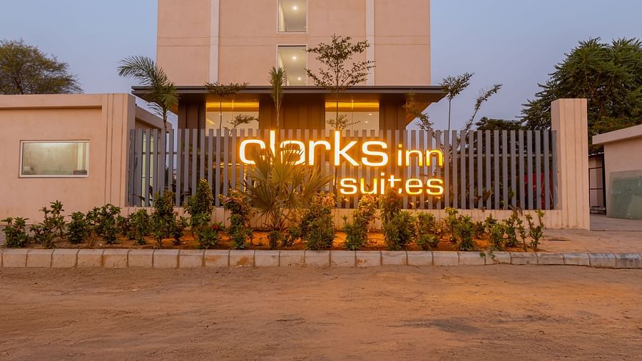 Clarks Inn Suites lit up with warm lights in front of the facade of Clarks Inn Suites Jaipur