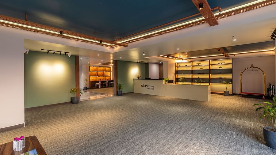 A well-lit reception at Clarks Inn Suites Jaipur, Ajmer Road featuring a reception desk and the entrance to the dedicated lobby area