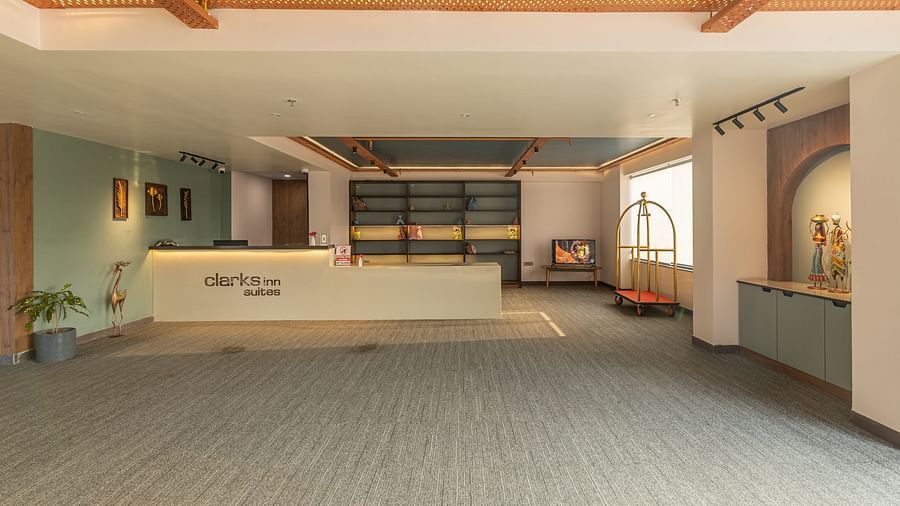 Reception area of Clarks Inn Suites Jaipur featuring a reception desk and a window beside it through which the sunlight makes it way into the reception