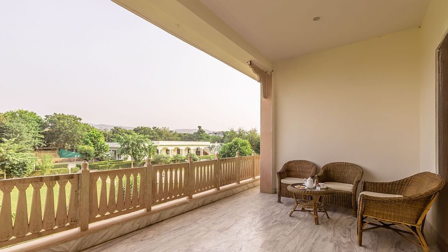 A private balcony at Clarks Inn Suites, Ranthambore with a seating area overlooking the resort grounds.