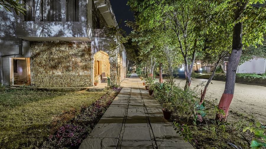 A lit pathway winding through the grounds of Clarks Inn Suites, Ranthambore at night.