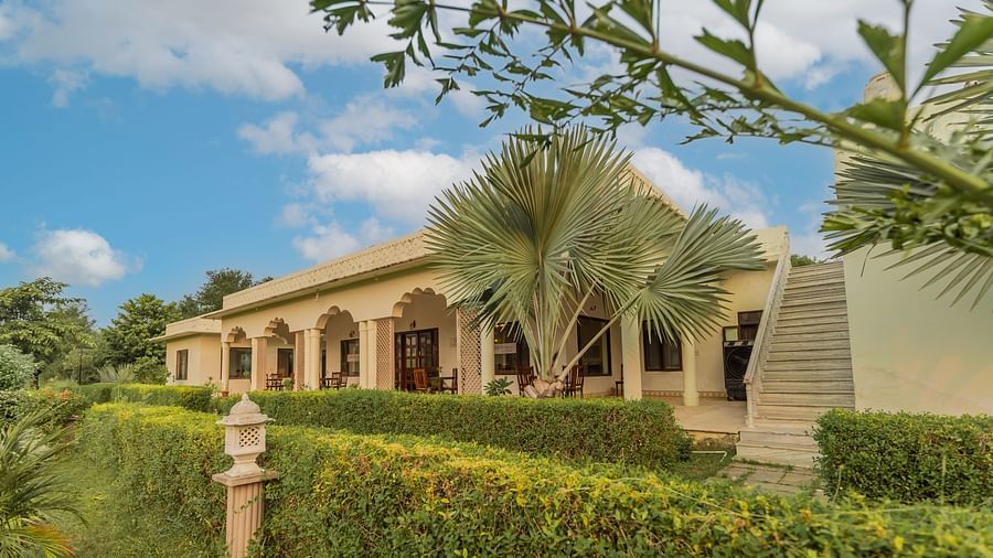 A view of Clarks Inn Suites, Ranthambore with lush greenery and a blue sky.