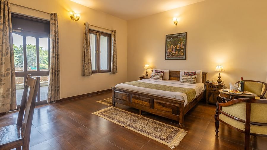 A spacious and comfortable guest room at Clarks Inn Suites, Ranthambore with a comfortable bed and a seating area.