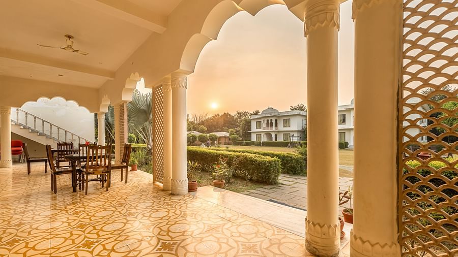 A view of the resort grounds at Clarks Inn Suites, Ranthambore with a beautiful sunset through the arches.