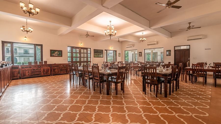 A spacious dining area at Clarks Inn Suites, Ranthambore with multiple tables and chairs.