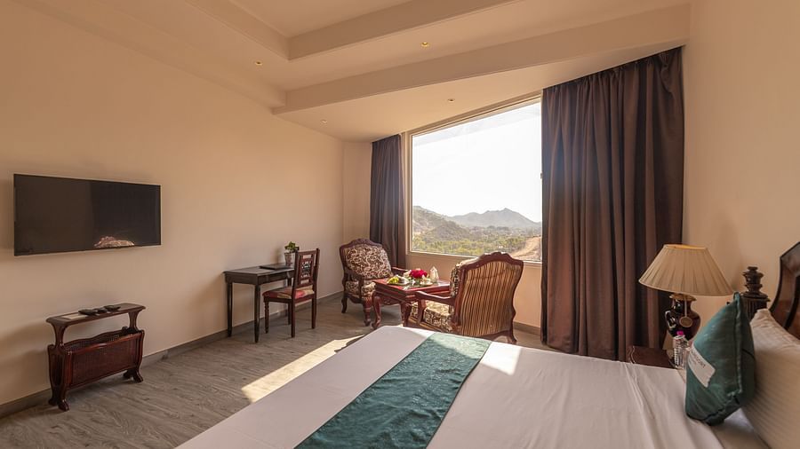 Scenic guest room with large window and seating at Clarks Resort The Archi's Castle, Ajmer.
