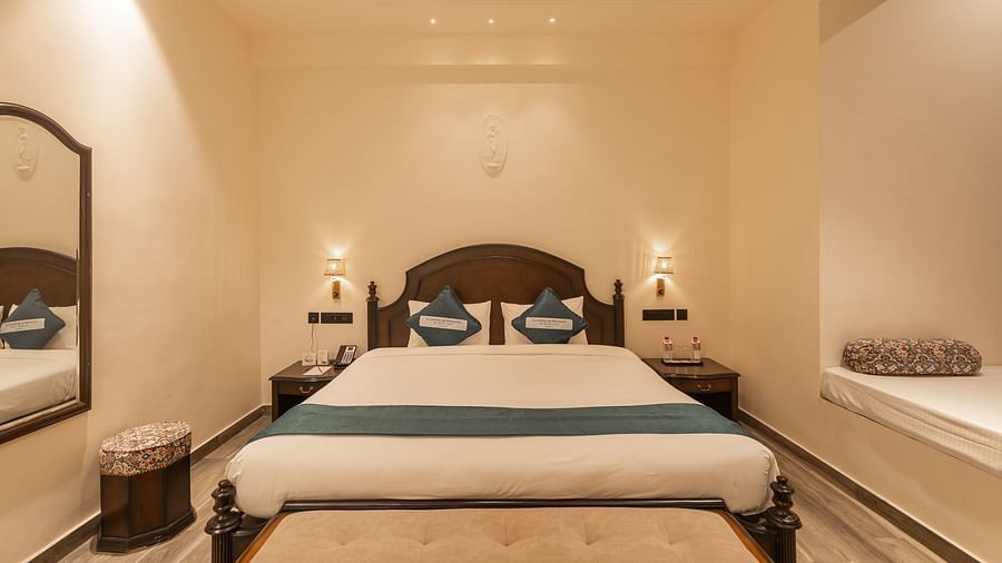 Spacious bedroom with twin lamps and seating at Clarks Resort The Archi's Castle, Ajmer.
