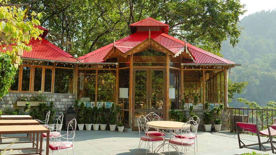 An outdoor gazebo with seating and a view of trees and mountains.