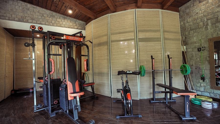 A gym with exercise equipment and a mirrored wall, interior setting.