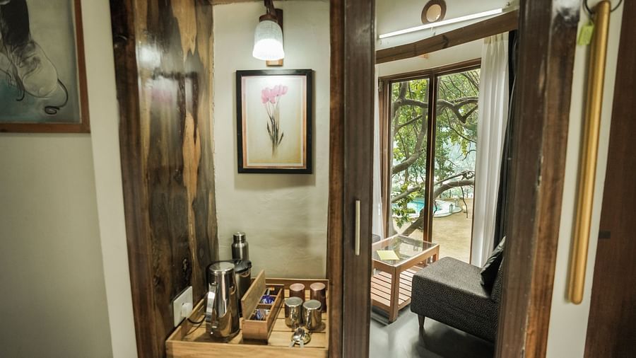 A room with a desk, a lamp, and a view of a garden - The Den Corbett Resort & Spa, Kumeria.