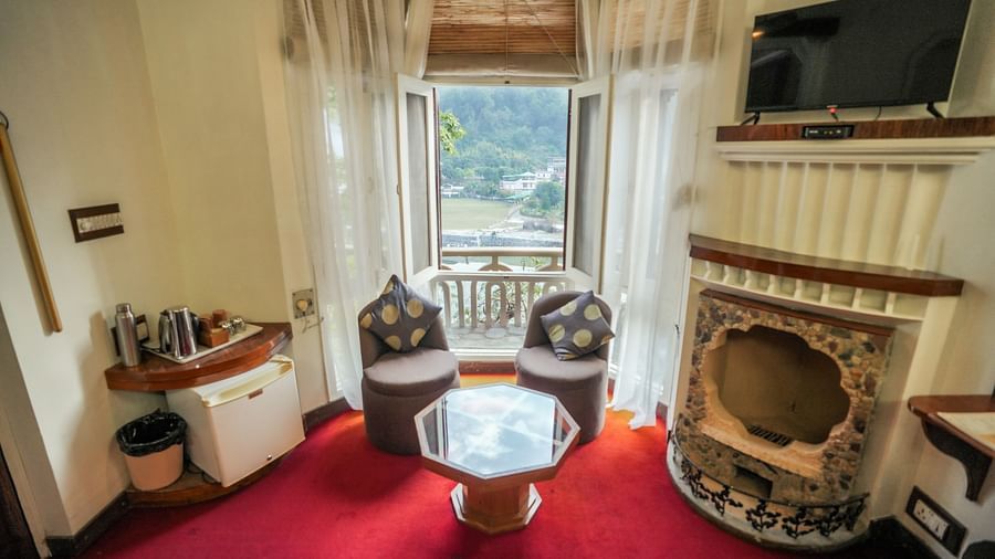 A living room with a couch, chairs, and a television, interior setting - The Den Corbett Resort & Spa, Kumeria.