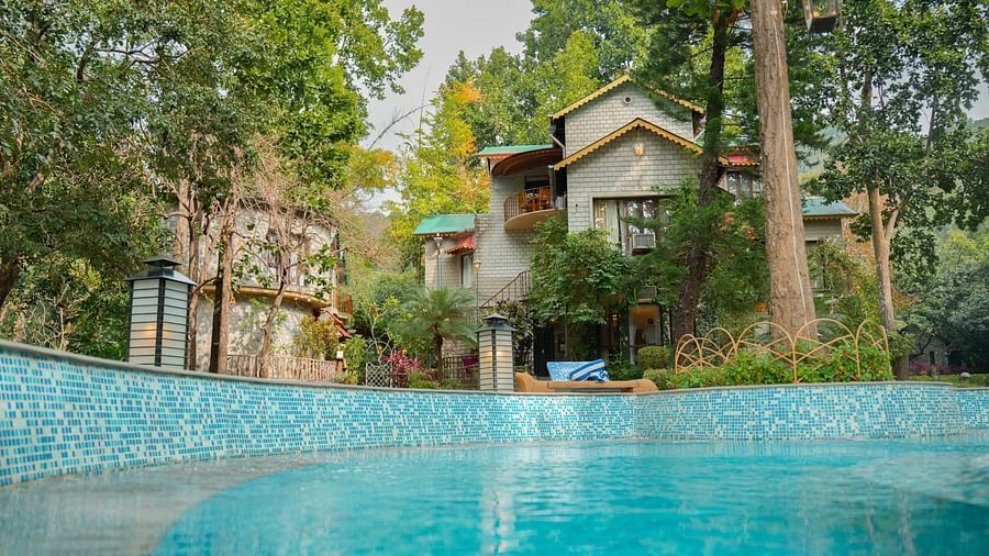 A swimming pool surrounded by trees and buildings, outdoor setting - The Den Corbett Resort & Spa, Kumeria.