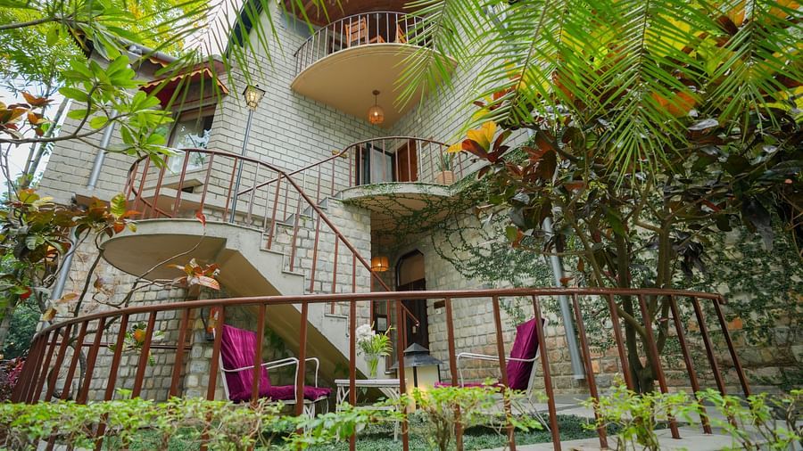 A multi-level building with balconies and plants, surrounded by trees and greenery - The Den Corbett Resort & Spa, Kumeria.