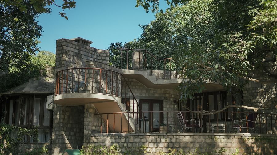 An exterior view of a building with a stone facade, surrounded by trees and greenery - The Den Corbett Resort & Spa, Kumeria.